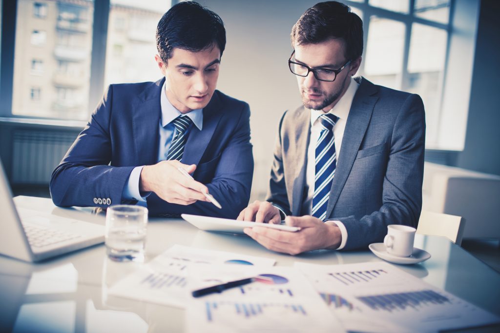 Two men in Professional Service looking at charts